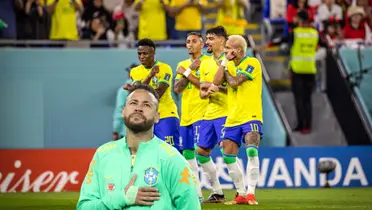 Brazil puts his hand on his chest while the rest of the Brazilian national team dance and celebrate together. (Source: Getty Images)
