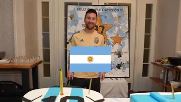 Lionel Messi smiles for a picture with his cake in front of him and the Argentina flag is in the middle. (Source: Messi Xtra X)
